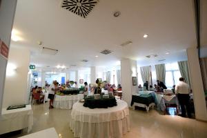 pokój ze stołami i osobami w restauracji w obiekcie Hotel Degli Aranci w mieście Vieste