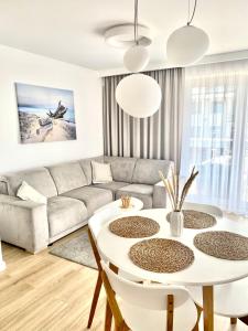 ein Wohnzimmer mit einem Sofa und einem Tisch in der Unterkunft Apartament NADMORSKI z Basenem Klifowa Rewal in Rewal