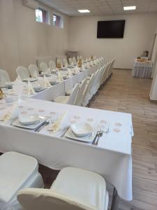 a large room with white tables and white chairs at Hotel Parkowy in Malbork
