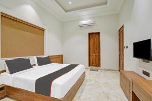 a bedroom with a bed and a flat screen tv at Ratna Vilas Palace in Rajkot