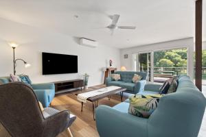 a living room with blue furniture and a flat screen tv at Reflection in Margaret River Town