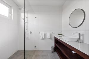a white bathroom with a sink and a mirror at Reflection in Margaret River Town +16 photos