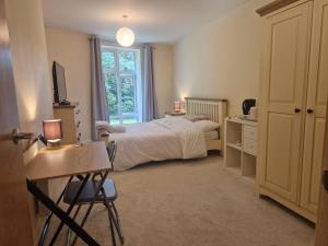 een slaapkamer met een bed, een bureau en een raam bij West Beck House in Darlington