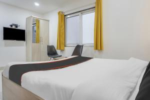 a bedroom with a bed and two chairs and a window at Collection O 83129 Hotel Galaxy Hospitality in Kharadi
