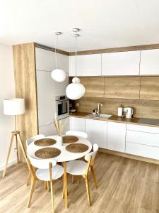 eine Küche und ein Esszimmer mit einem Tisch und Stühlen in der Unterkunft Apartament NADMORSKI z Basenem Klifowa Rewal in Rewal