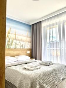 1 Schlafzimmer mit 2 Betten und einem großen Fenster in der Unterkunft Apartament NADMORSKI z Basenem Klifowa Rewal in Rewal