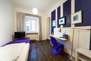 a bedroom with a bed and a desk with a computer at Hotel Bergbauer in Neuburg an der Donau