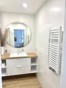 ein Bad mit einem Waschbecken und einem Spiegel in der Unterkunft Apartament NADMORSKI z Basenem Klifowa Rewal in Rewal