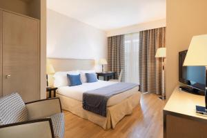 a hotel room with a bed and a television at Hotel Nazionale in Desenzano del Garda