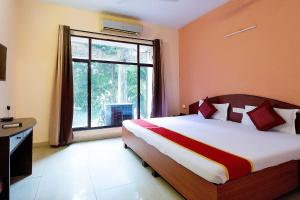 a bedroom with a bed and a large window at Lake View Resort in Kolkata