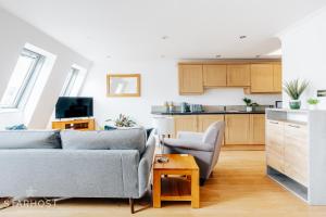 a living room with two couches and a kitchen at Central 3 bed apartment at Regents Court, Newbury in Newbury