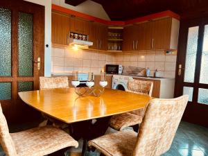 a kitchen with a wooden table and some chairs at Apartman Tóth György in Bačka Topola