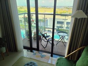 a room with a balcony with a table and chairs at Ina apartment - Nera garden Hue in Hue