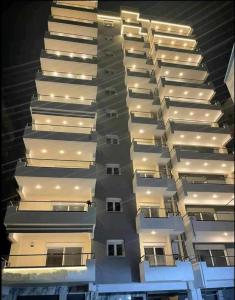 a tall apartment building with white balconies at night at Vv Cosy Host 2 in Larisa