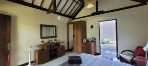 uma sala com um quarto com uma cama e um espelho em Rumah Sunyi em Gili Trawangan