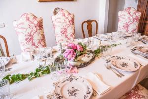 una mesa con platos, vasos y flores. en Prestigious manor with pool, air conditioning, en Monte Campano