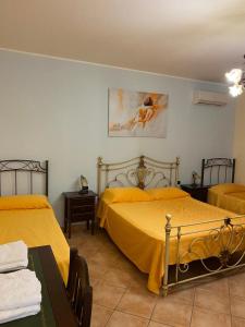 1 dormitorio con 2 camas con sábanas amarillas en DOLCE DORMIRE, en Albanella