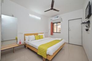 een slaapkamer met een bed en een flatscreen-tv bij Jalsa Villas in Saputara