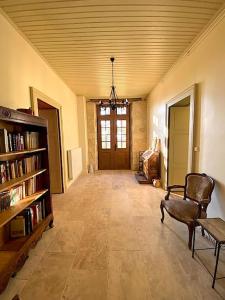 uma sala de estar com uma estante de livros e uma cadeira em Gîte de charme avec piscine dans le Gers « Le Clos Boissière » em Valence-sur-Baïse