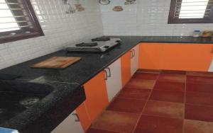 a kitchen with a stove and a counter top at Mango Ville in Bangalore