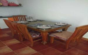 - une table en bois avec des chaises et des assiettes dans l'établissement Mango Ville, à Bangalore