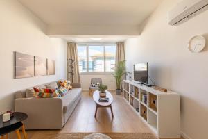 a living room with a couch and a tv at City Center Apartment in Nicosia