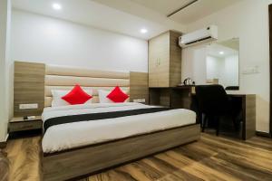 a bedroom with a bed with red pillows and a desk at OYO Flagship Hotel Gn Pride in Amritsar