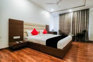 a bedroom with a large bed with red pillows at OYO Flagship Hotel Gn Pride in Amritsar