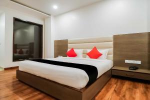 a bedroom with a large bed with red pillows at OYO Flagship Hotel Gn Pride in Amritsar