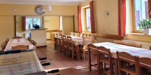 a restaurant with tables and chairs and a clock on the wall at Chalupa Chiranka in Lipova Lazne