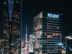 a tall building with a sign on it in a city at Regent Shanghai Pudong - Complimentary first round minibar per stay - including a bottle of wine in Shanghai