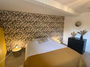 um quarto com uma cama e uma parede coberta de troncos em Grange rénovée esprit loft Côte d'Opale em Wierre-Effroy