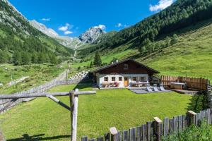 a house in the middle of a green mountain at Alm Chalet Oberkofl in San Giacomo