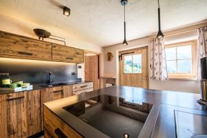 a kitchen with wooden cabinets and a counter top at Alm Chalet Oberkofl in San Giacomo +15 photos