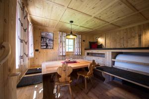 a dining room with a table and chairs in a cabin at Alm Chalet Oberkofl in San Giacomo