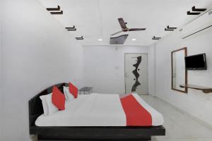 um quarto com uma cama e uma televisão na parede em Flagship Hotel Rudra Palace em Ahmedabad