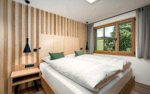 una camera da letto con un grande letto bianco e una finestra di Tschitthof Wohnung Gill a Avelengo