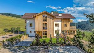 a large house with wooden walls and a hill at Tschitthof Wohnung Gill in Avelengo