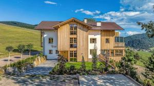 una grande casa con pareti in legno e una collina di Tschitthof Wohnung Gill a Avelengo