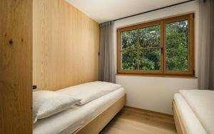 una piccola camera da letto con due letti e una finestra di Tschitthof Wohnung Gill a Avelengo