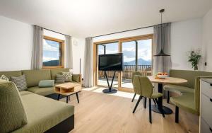 un soggiorno con un divano e un tavolo con una televisione di Tschitthof Wohnung Gill a Avelengo