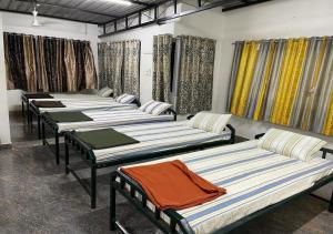 a row of beds lined up in a room at Yelagiri Naksha Tree Hotels in Yelagiri