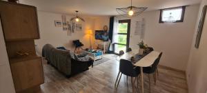ein Wohnzimmer mit einem Sofa und einem Tisch in der Unterkunft Au calme, confortable avec terrasse in Le Pouzin
