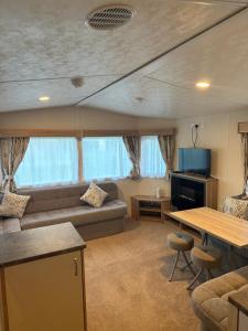 ein Wohnzimmer mit einem Sofa und einem Tisch in der Unterkunft Billing Aquadrome Luxury Static Caravan in Great Billing