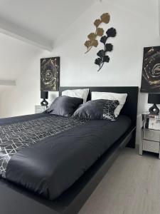 a bedroom with a black bed with two lamps at RESIDENCE FAIDHERBE avec terrasse et jardin in Champigny-sur-Marne