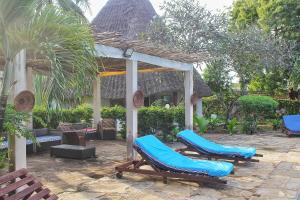 a patio with two blue chairs and a gazebo at Diani Beach Greenland Villa 2 Bedroom in Ukunda
