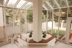 a conservatory with glass walls and a pillar at Grand Park rooms & apartments in Čačak