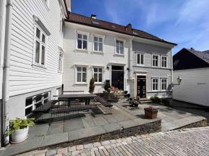 een wit huis met een patio ervoor bij Koslig leilighet i Bergens smørøye in Bergen