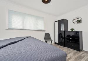 a bedroom with a bed and a desk and a chair at Berwick Apartment by Klass Living Coatbridge in Coatbridge