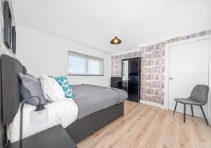 a bedroom with a bed and a chair in it at Berwick Apartment by Klass Living Coatbridge in Coatbridge